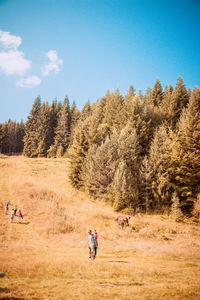 People walking on field against sky