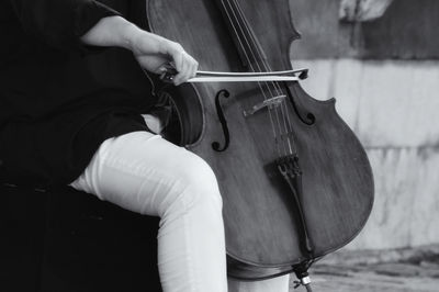 Midsection of man playing cello