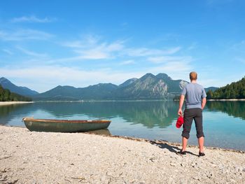 Modern sport fishing paddle boat anchored on shore of the lake bay. peaceful level of lake