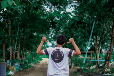 Rear view of man standing by plants