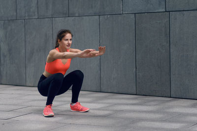 Woman in sports clothing doing squats