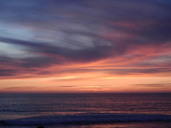 Scenic view of sea against dramatic sky during sunset