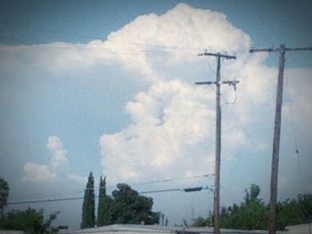 Power lines against cloudy sky