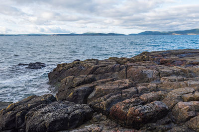 Scenic view of rocks on beach against sky