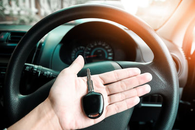 Cropped hand holding key in car