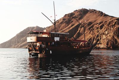 Boat on sea against mountain range