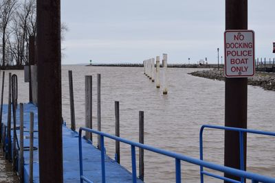 Close-up of railing by sea against sky