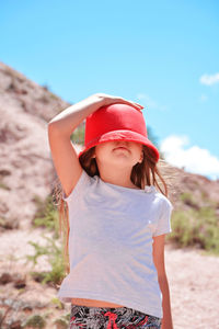 Full length of girl wearing hat standing against sky