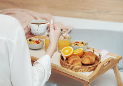 Romantic breakfast with coffee, waffles, orange juice and rose flowers.