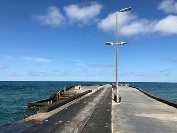 Street amidst sea against sky