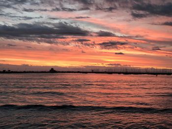 Scenic view of sea against dramatic sky during sunset