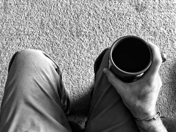 Low section of woman holding coffee cup