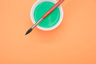 High angle view of bird on table against orange background