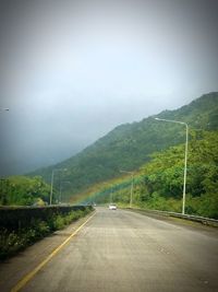 Road by mountain against sky