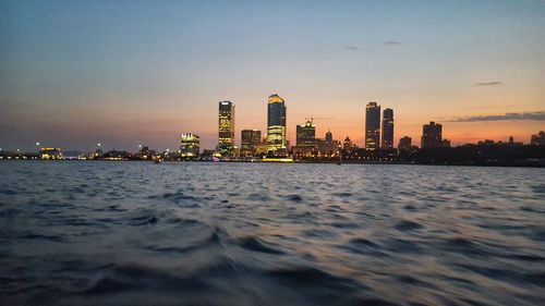 City at waterfront during sunset