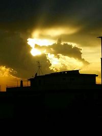 Silhouette of building against dramatic sky