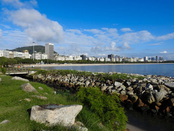 Scenic view of river by buildings against sky