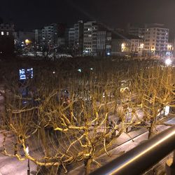 High angle view of illuminated street amidst buildings at night