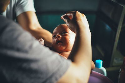 Close-up of hands holding newborn baby in hospital