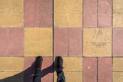 Low section of man standing on footpath