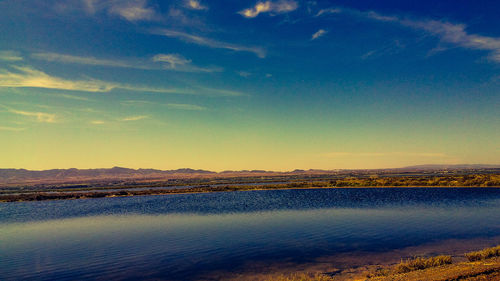 Scenic view of lake against sky at sunset