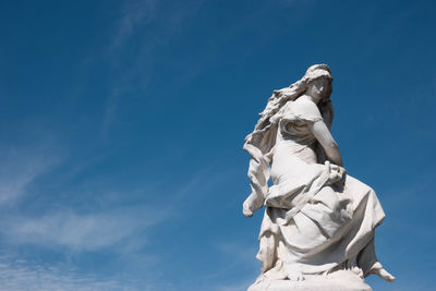 Low angle view of statue against blue sky