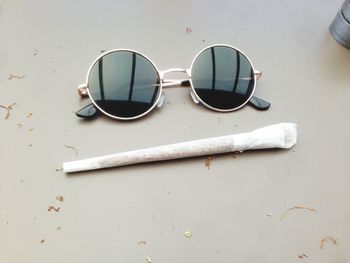 High angle view of sunglasses with marijuana joint on table