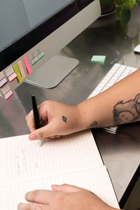 Woman hand with forearm tattoo writing