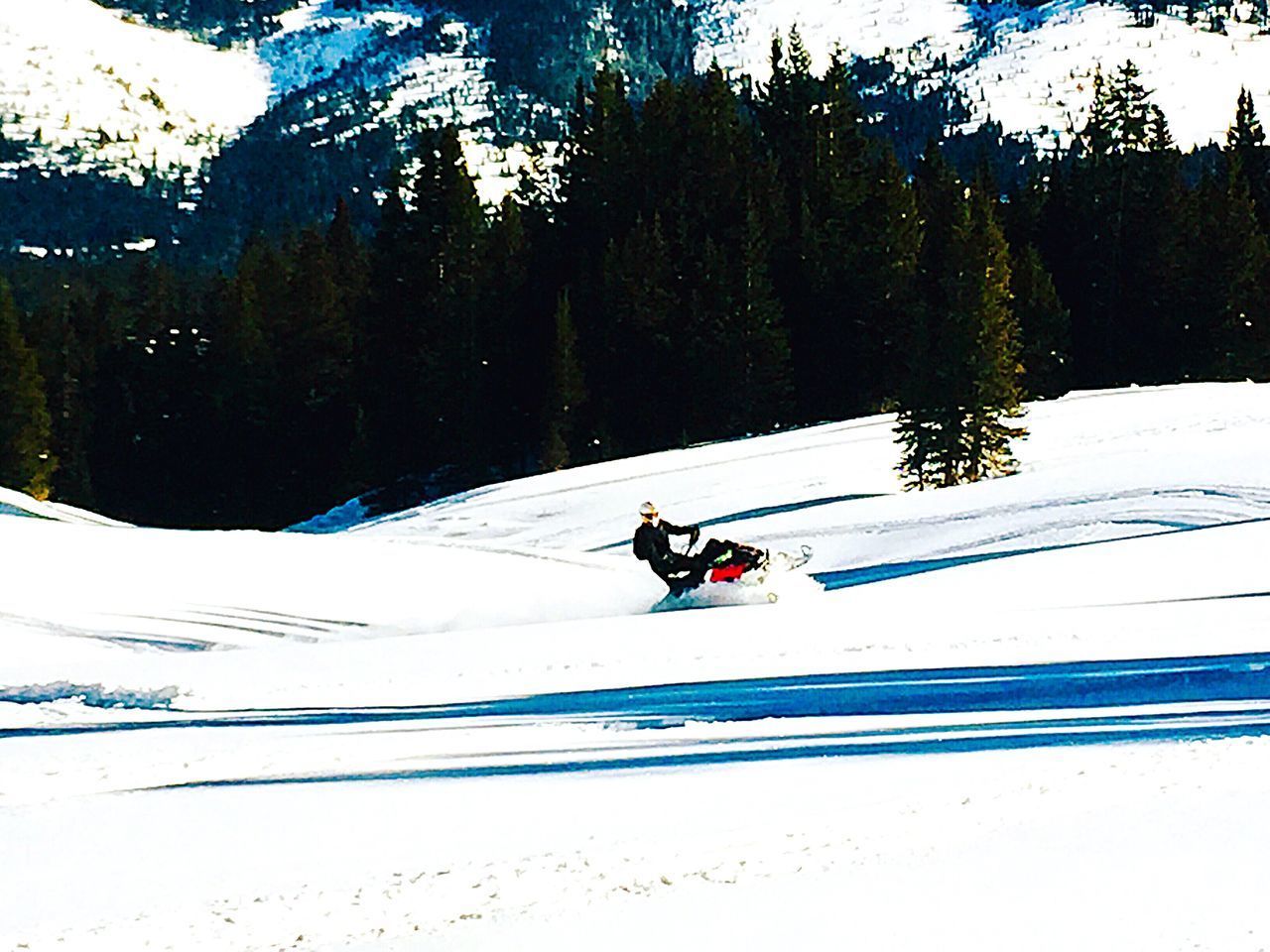 MAN RIDING MOTORCYCLE ON SNOW COVERED FIELD