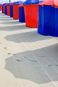 Row of multi colored umbrellas on footpath during sunny day