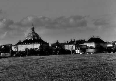 View of church in town against cloudy sky