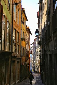 Narrow street amidst buildings in city against sky