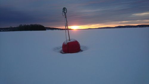 Scenic view of frozen lake against sky during sunset