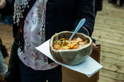 Midsection of person holding ice cream in bowl