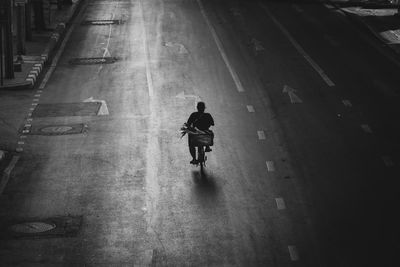 Man riding bicycle on building in city