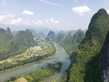 Scenic view of river by mountains against sky