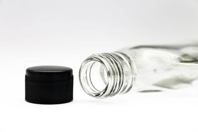 Close-up of glass jar on table against white background