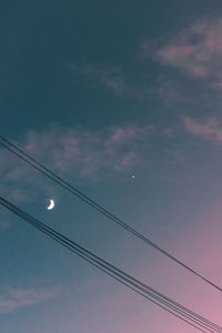 Low angle view of power cables against sky