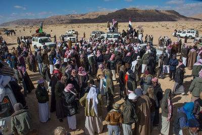 Panoramic view of crowd standing on mountain against sky