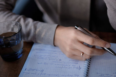 Close-up of hand holding drink on table