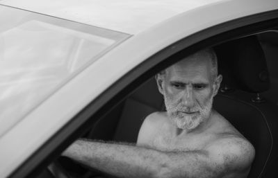 Monochrome of portrait of shirtless adult man in car