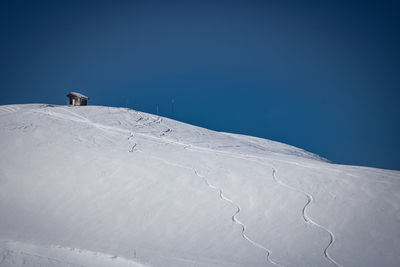 Snow covered landscape against clear sky