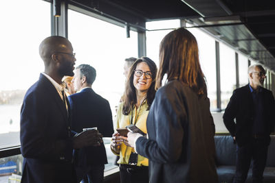 Male and females entrepreneurs discussing while standing in office