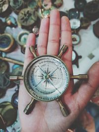 Cropped hand of person holding navigational compass