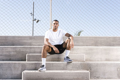 Full length portrait of man sitting on staircase