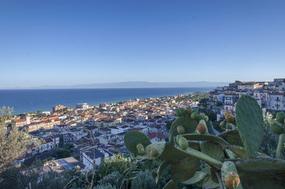 Townscape by sea against clear sky