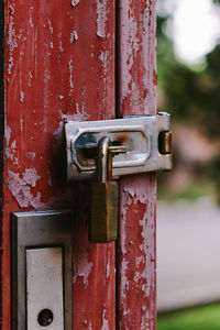 The old rusty padlock on the red door