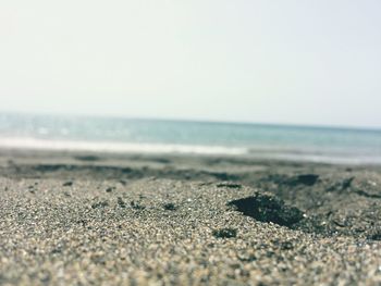 Close-up of sand on beach against clear sky