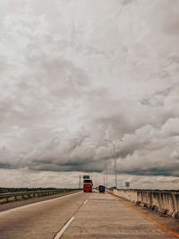 Car on road against cloudy sky