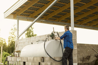 Low angle view of man with machinery at farm